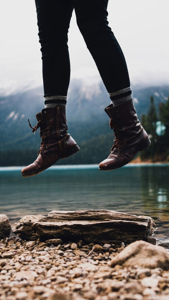 person jumped near lake shore during daytime